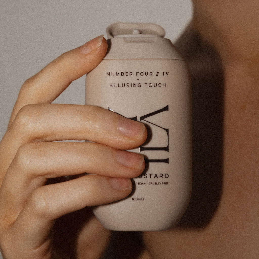Hand holding a beige bottle labeled 'Number Four' against a neutral background