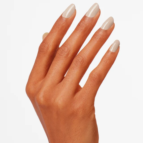Hand with beige nail polish on a white background