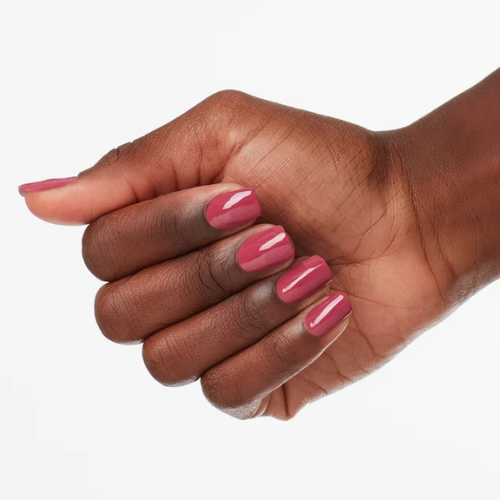 Hand with pink nail polish on a white background