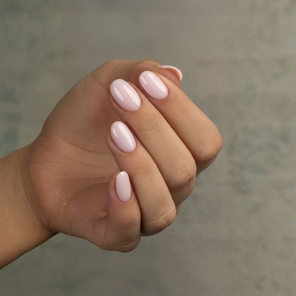 Hand with pink nail polish on a blurred background