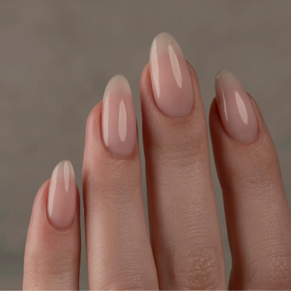 Close-up of a hand with nude-colored nail polish on a neutral background