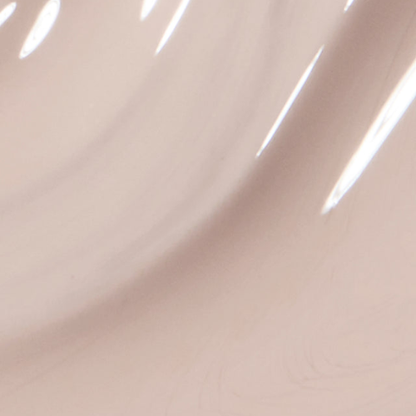 A close-up of a glossy, smooth surface in a very light warm beige or blush tone with soft curved highlights.