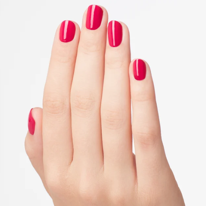 A close-up of a hand with manicured nails painted in a glossy bright pink color, set against a clean white background.