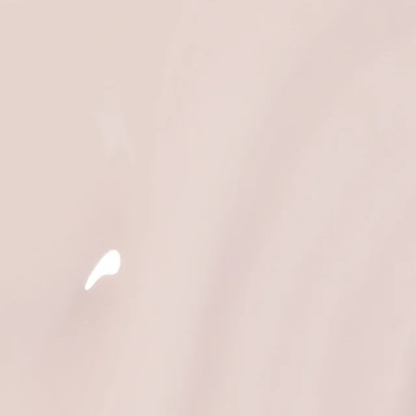 A close-up of a smooth, glossy light beige surface with a small white highlight near the lower left.