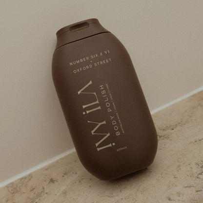 Brown bottle of WIL body polish on a beige surface with a neutral background