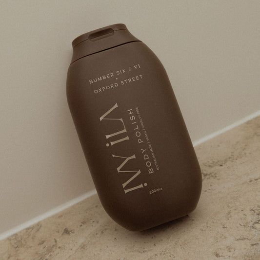 Brown bottle of WIL body polish on a beige surface with a neutral background