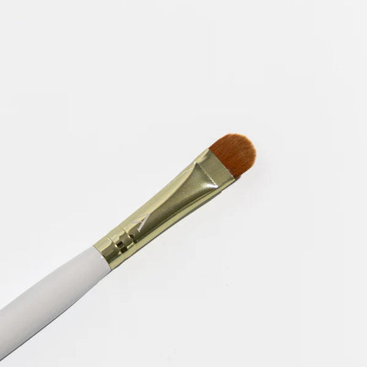 Makeup brush with white handle and brown bristle on a light gray background