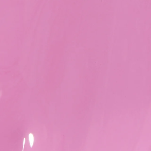 A solid pink color swatch with a subtle sheen and light reflection in the lower-left corner.