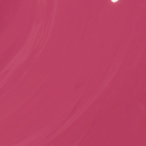 A close-up of a solid pink color with subtle texture and a small bright highlight near the top right corner.