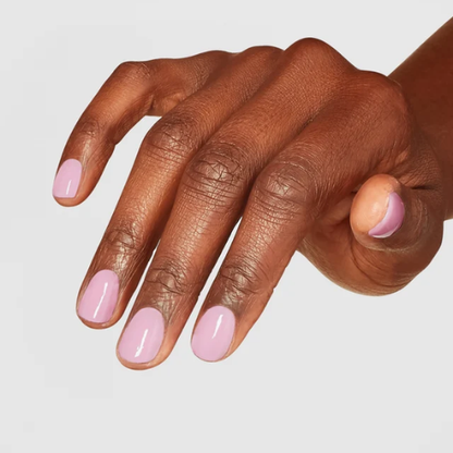 Hand with pink nail polish on a light gray background