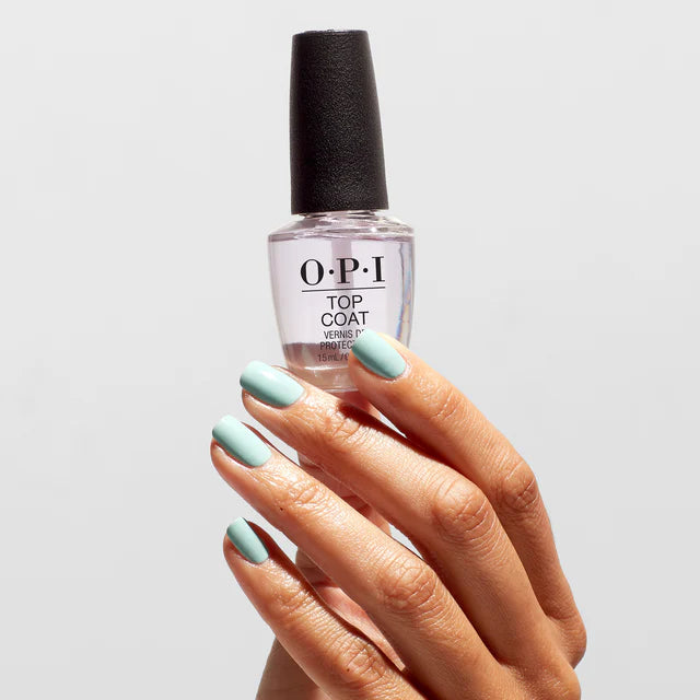 Hand with light green nails holding a bottle of OPI nail polish.